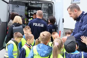 policjanci rozmawiają z dziećmi przy radiowozie