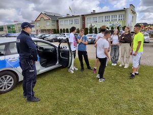 Policjant rozmawia z dziećmi na festynie szkolnym