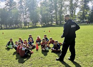 Policjant rozmawia z dziećmi na boisku