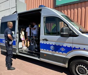 policjanci w centrum handlowym w Rumi rozmawiają o bezpieczeństwie z dziećmi i dorosłymi- policjanci wrd na zewnątrz pokazują radiowóz