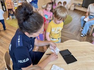 Policjantka wykonuje dzieciom daktyloskopię