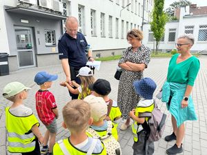 Policjant dzieciom pokazuje kajdanki.