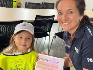 Policjantka pozuje z dziewczynką, która wręczyła jej laurkę od przedszkola.