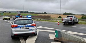 Miejsce kolizji drogowej, na pierwszym planie policyjny radiowóz, w tle rozbita toyota