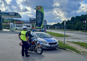 Policjant rozmawia z drugim motocyklistą.