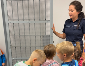 Policjantka prezentuje tymczasowe pomieszczenia dla osób zatrzymanych.