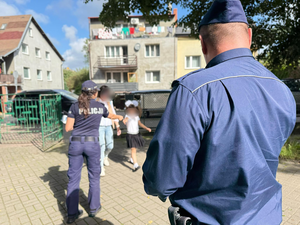 Policjanci rozdają dzieciom odblaski.