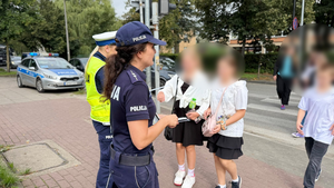 Policjanci rozdają dzieciom odblaski.