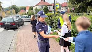Policjanci rozdają dzieciom odblaski.