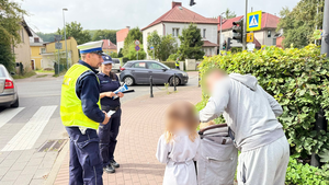 Policjanci rozdają dzieciom odblaski.