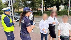 Policjanci rozdają dzieciom odblaski.