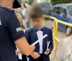 Policjanci rozdają dzieciom odblaski.