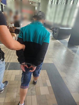 Policjant prowadzi zatrzymanego