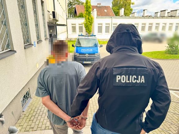 Policjant prowadzi zatrzymanego