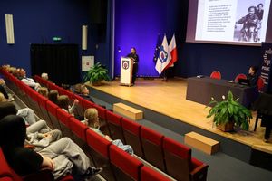 Zdjęcie sali kinowej na której siedzą goście, a policjanci prowadzą spotkanie