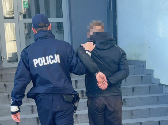 Policjant prowadzi zatrzymanego