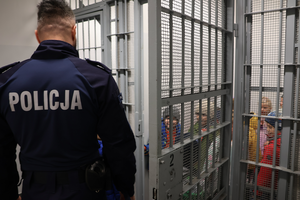 Dzieci zwiedzają pomieszczenie dla osób zatrzymanych