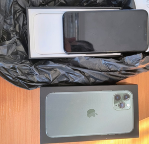 telefon komórkowy oraz pudełko leżą na biurku
