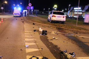 Miejsce zdarzenia drogowego, w tle widać radiowóz, biały samochód - mercedes