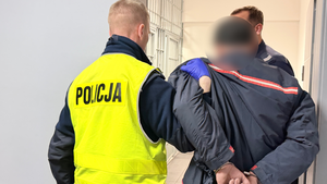 Policjanci prowadzą zatrzymanego