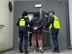 Policjanci wprowadzają zatrzymaną do celi