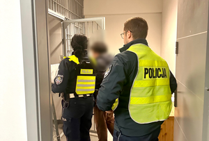 policjanci wprowadzają zatrzymają do komendy