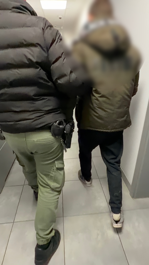 Policjant prowadzi zatrzymanego