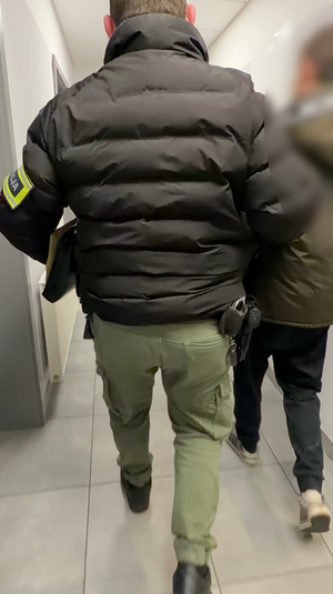 Policjant prowadzi zatrzymanego