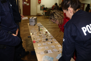 Policjantka rozkłada rekwizyty z walizki na stole