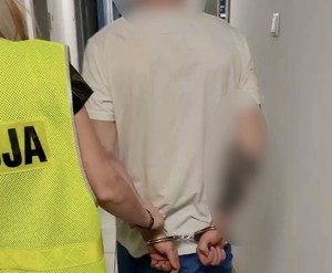 Policjantka prowadzi zatrzymanego