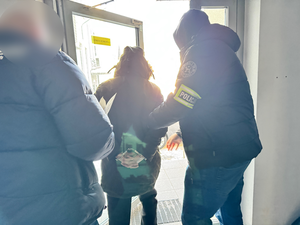 Policjanci wyprowadzają zatrzymanego z komendy.