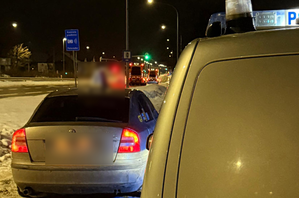 Zatrzymana skoda i radiowóz przy drodze (nocą)