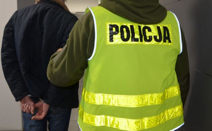 Policjant prowadzi zatrzymanego mężczyznę