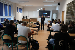 Policjantka prowadzi spotkanie z uczniami, promuje zawód policjanta i wyświetla film promocyjny.