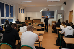 Policjantka prowadzi spotkanie z uczniami, promuje zawód policjanta i wyświetla film promocyjny.