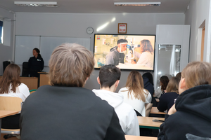 Policjantka prowadzi spotkanie z uczniami, promuje zawód policjanta i wyświetla film promocyjny.