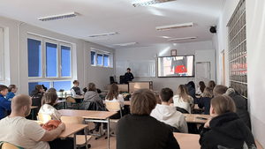 Policjantka prowadzi spotkanie z uczniami, promuje zawód policjanta i wyświetla film promocyjny.