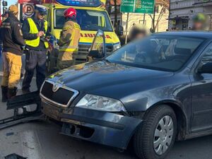 Policjant pracuje na miejscu wypadku z udziałem skody i motocykla junak