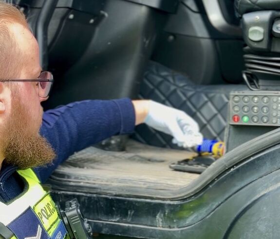 Policjant spod siedzenia wyjmuje zawiniątko - sreberko w którym jest marihuana