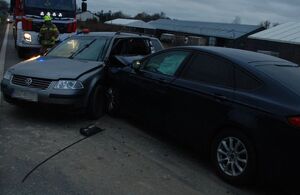 Miejsce zdarzenia drogowego na którym jest tłoczno bo stoją pojazdy, a na jednym ze zdjęć widać auta biorące udział w zdarzeniu gdzie Ford uderzył w bok Volkswagena