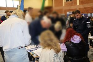 Policjanci na targach pracy rozmawiają z osobami zainteresowanymi służbą w Policji.