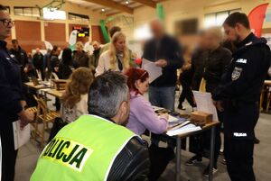 Policjanci na targach pracy rozmawiają z osobami zainteresowanymi służbą w Policji.