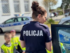 Policjantka oprowadza dzieci po komendzie i rozmawia z nimi o bezpieczeństwie