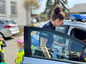 Policjantka oprowadza dzieci po komendzie i rozmawia z nimi o bezpieczeństwie