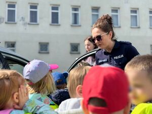 Policjantka oprowadza dzieci po komendzie i rozmawia z nimi o bezpieczeństwie