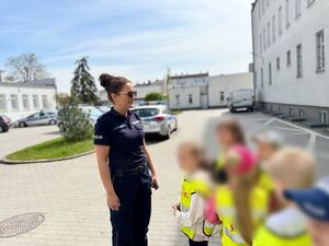 Policjantka oprowadza dzieci po komendzie i rozmawia z nimi o bezpieczeństwie