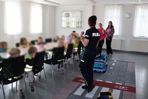 Policjantka oprowadza dzieci po komendzie i rozmawia z nimi o bezpieczeństwie
