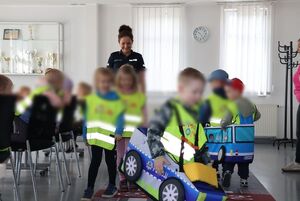 Policjantka oprowadza dzieci po komendzie i rozmawia z nimi o bezpieczeństwie