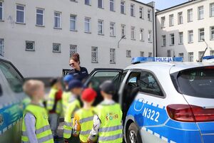 Policjantka oprowadza dzieci po komendzie i rozmawia z nimi o bezpieczeństwie