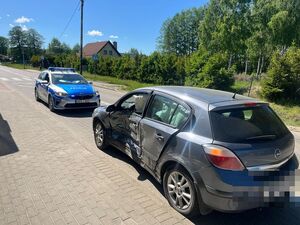 na pierwszym planie opel z rozbitymi bokiem samochodu a za nim stoi radiowóz